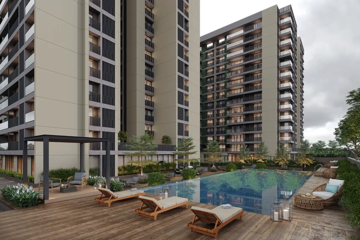 Área de lazer de condomínio residencial com piscina, deck e espreguiçadeiras entre as torres